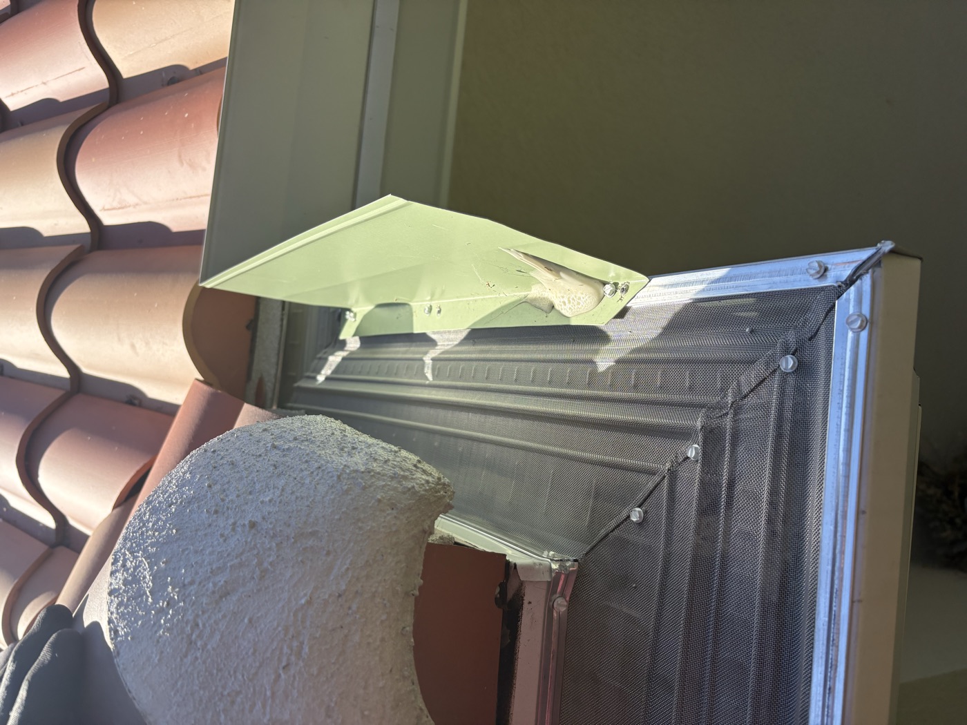 Micro-mesh gutter guard fitted along a tile roofline